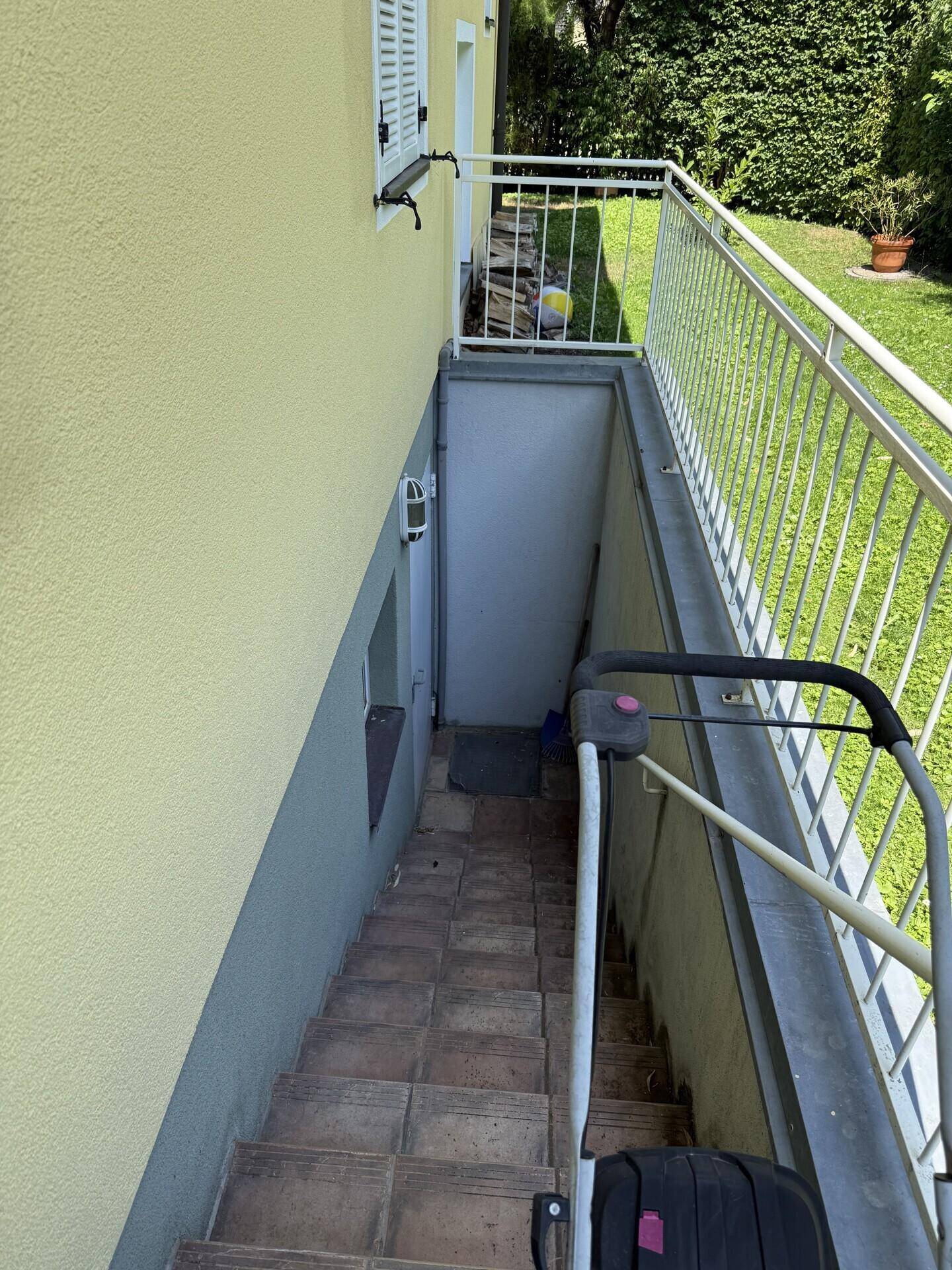 Außentreppe mit Geländer führt zum Kellereingang des Hauses.