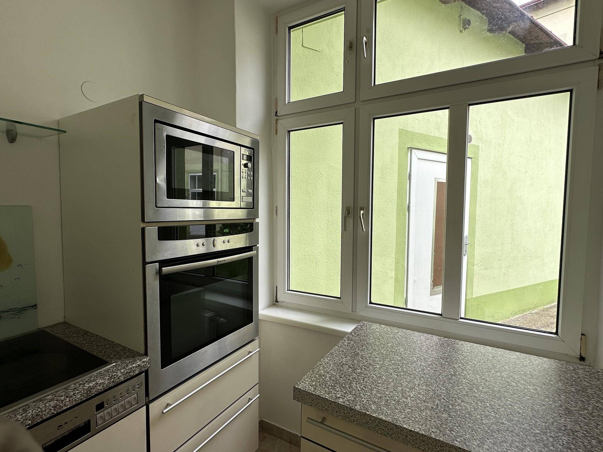 Küche mit Fenster, das viel Tageslicht hereinlässt und einen Blick nach draußen bietet.