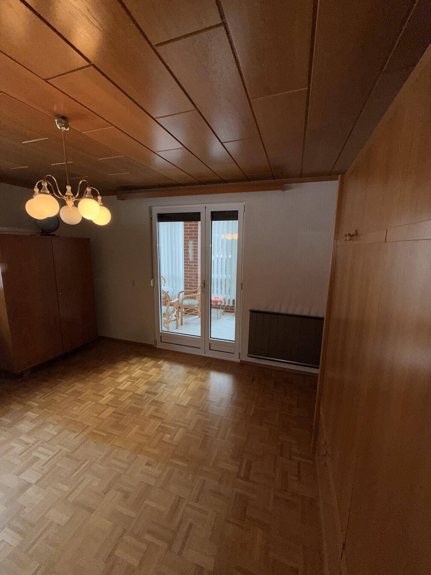 Zimmer mit Parkettboden und Holzdecke, mit Zugang zum Wintergarten.