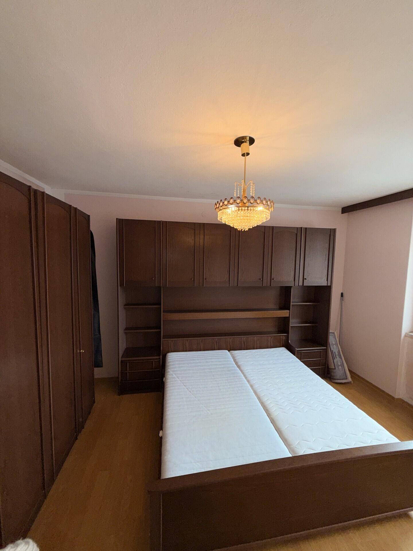 Schlafzimmer mit Einbauschränken und Doppelbett, bietet viel Stauraum.