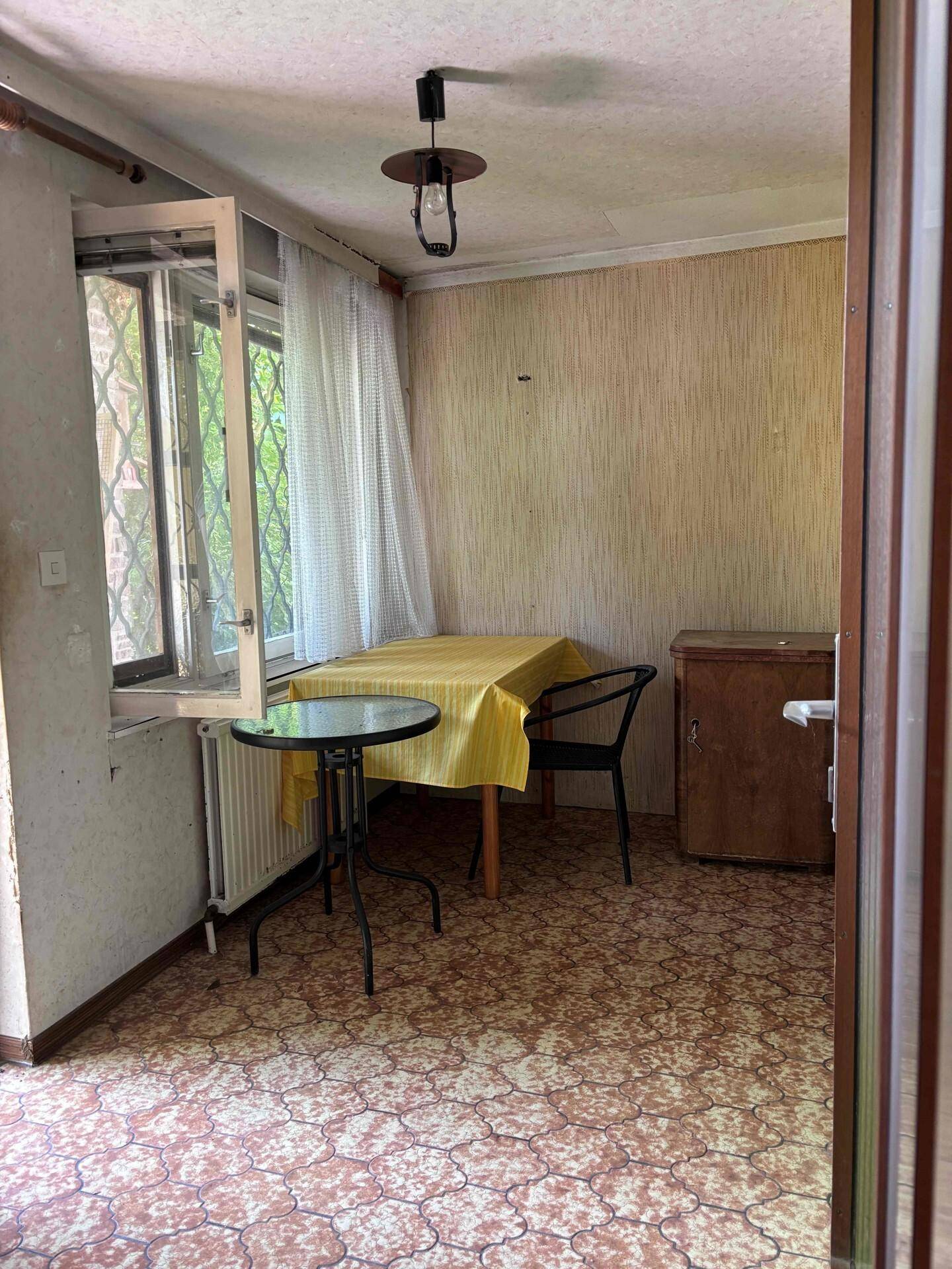 Gemütlicher Essbereich mit Tisch, Stühlen und Fenster mit Vorhängen.