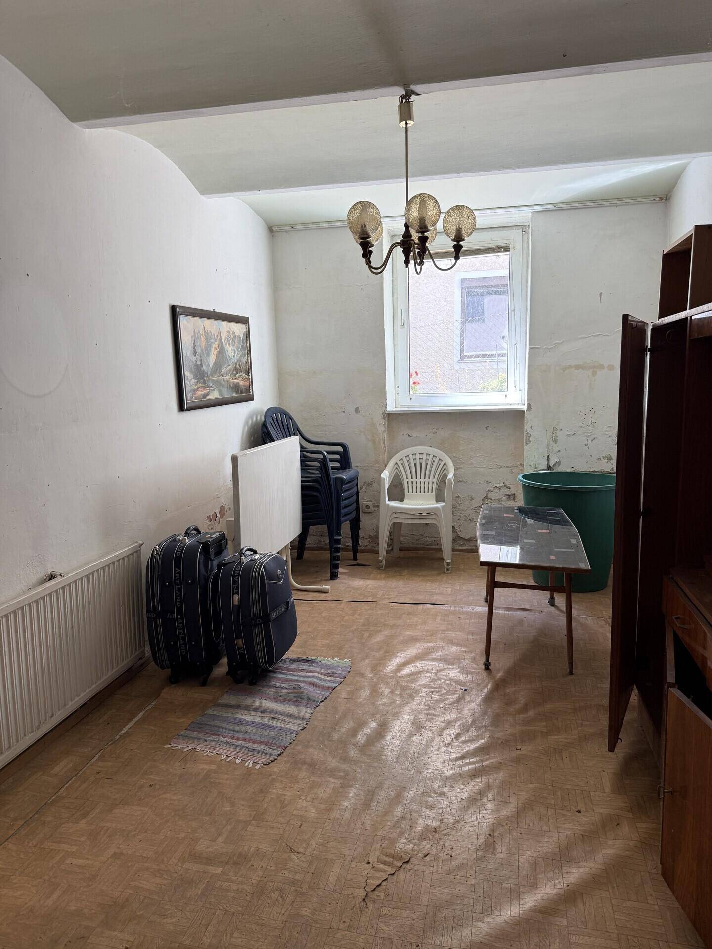 Kellerraum mit Fenster, Heizkörper und verschiedenen Gegenständen, die gelagert werden.