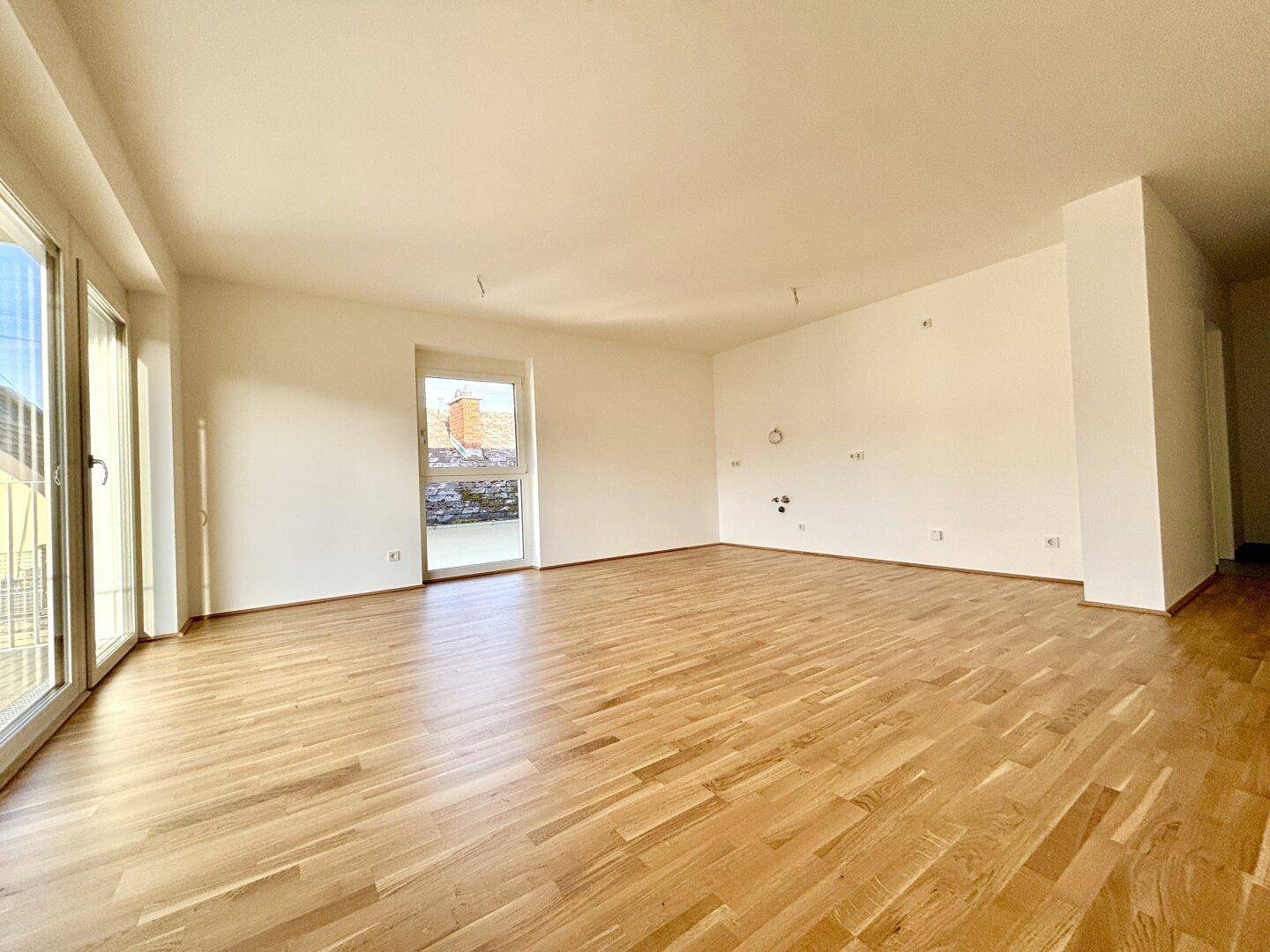 Geräumiges, helles Zimmer mit Parkettboden und großen Fenstern, bereit für die Einrichtung.