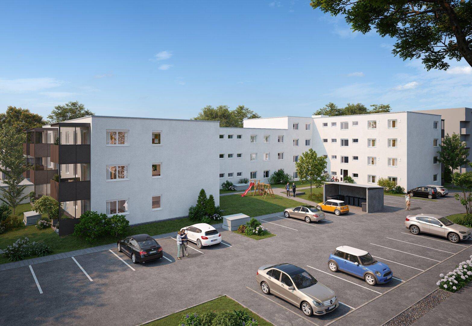 Moderne Wohngebäude mit Parkplätzen und einem Spielplatz in einer grünen Umgebung.