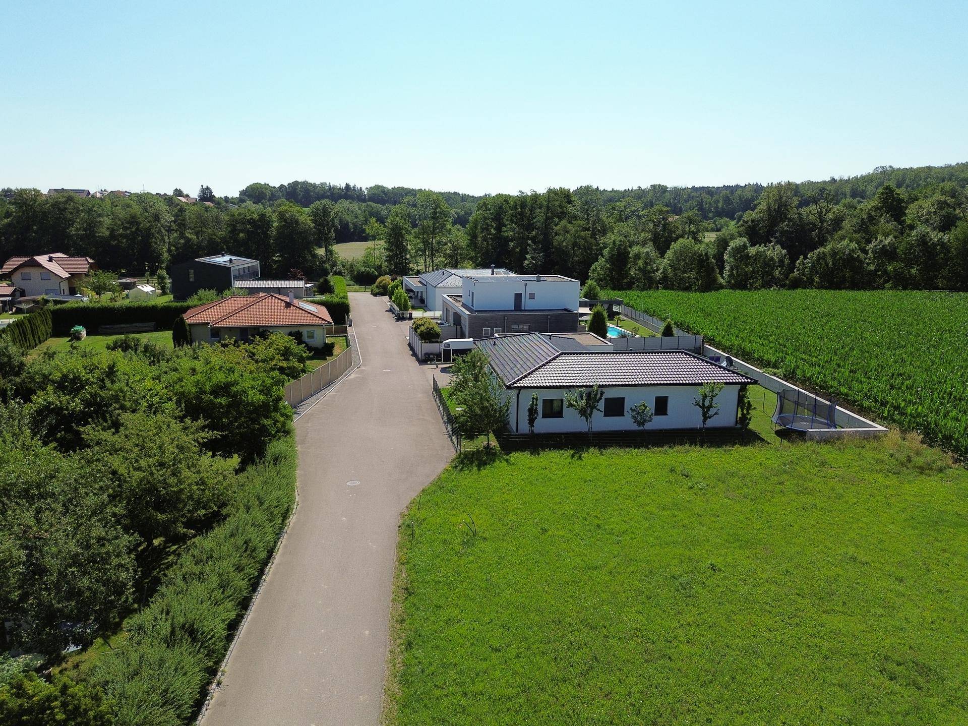 Luftaufnahme einer Wohnsiedlung mit modernen Häusern, umgeben von grüner Landschaft.