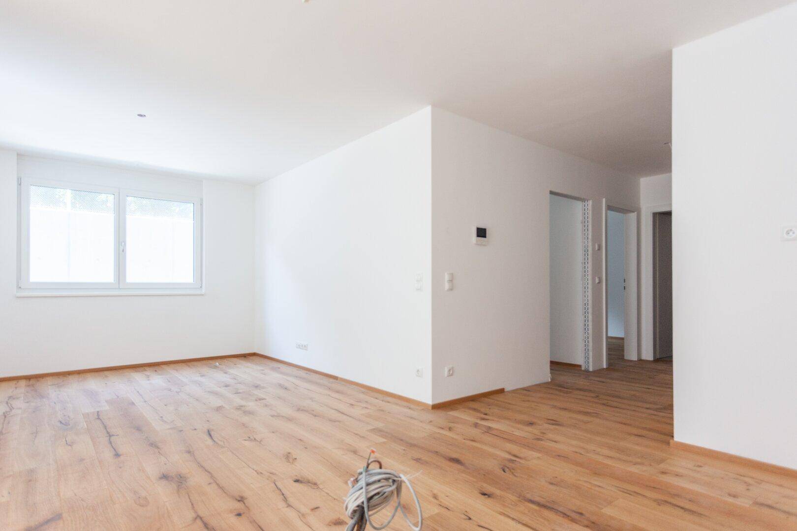 Geräumiger, unmöblierter Raum mit Holzfußboden und einem Fenster, ideal für individuelle Gestaltung.