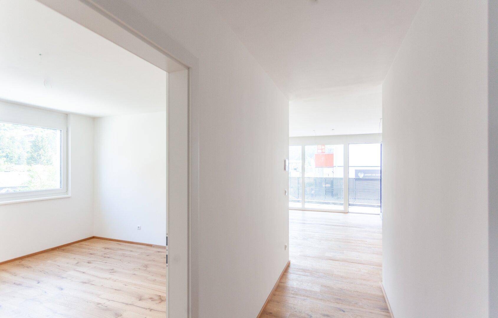 Heller Flur mit Holzboden, der zu weiteren Räumen führt.
