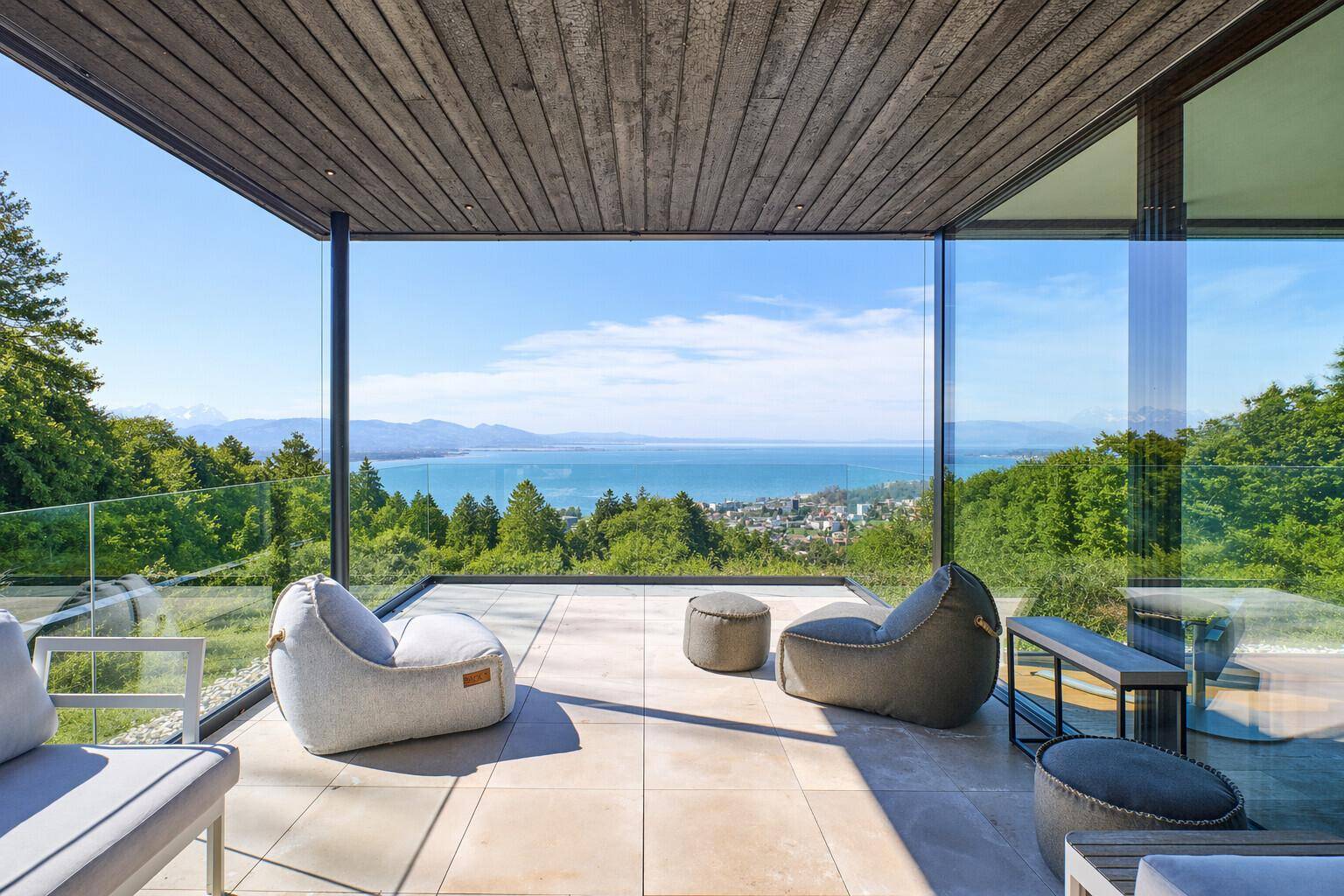 Geräumige überdachte Terrasse mit bequemen Sitzgelegenheiten und atemberaubendem Blick auf den See.