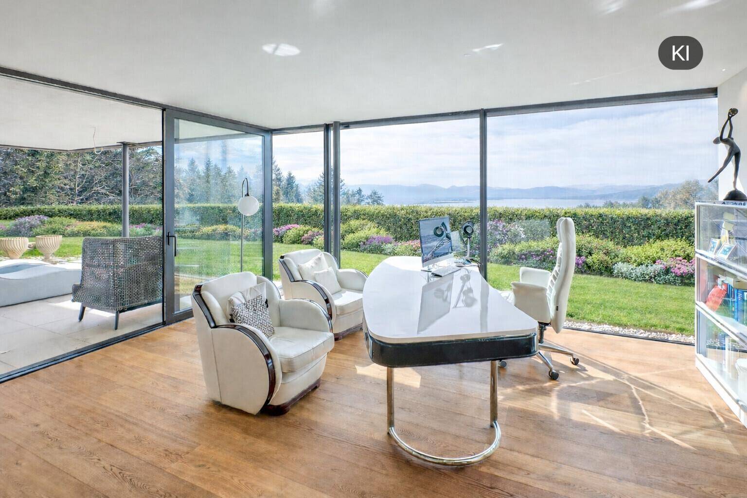 Heller Arbeitsbereich mit elegantem Schreibtisch und Panoramablick auf den See und die grüne Landschaft.