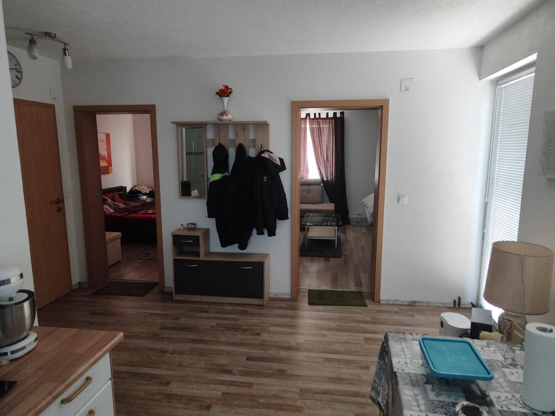 Eingangsbereich mit Garderobe, Laminatboden und Zugang zu verschiedenen Zimmern des Hauses.