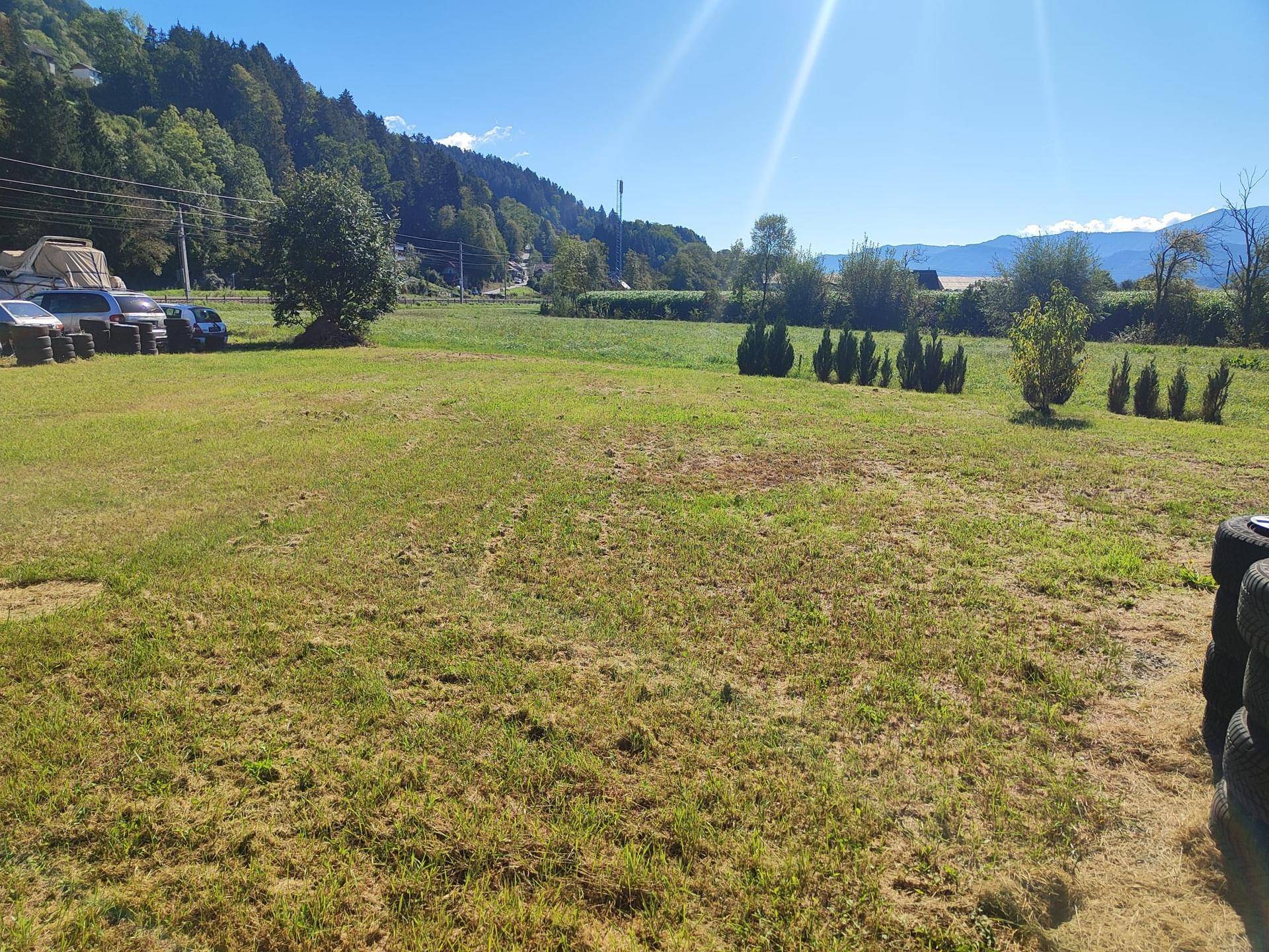Weitläufige Grünfläche mit Rasen und Blick auf die umliegende Berglandschaft an einem sonnigen Tag.