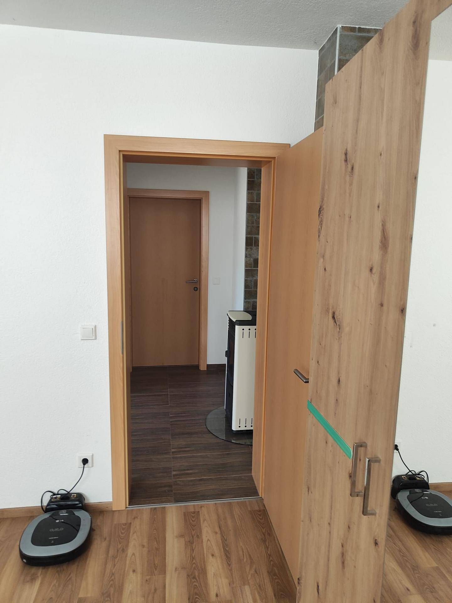 Flur mit Holztüren und Laminatboden, der zu weiteren Räumen im Haus führt.