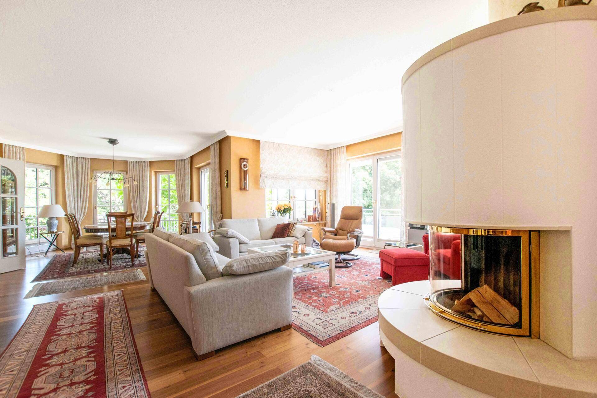 Geräumiger Wohn- und Essbereich mit Kamin, Parkettboden und Zugang zur Terrasse.