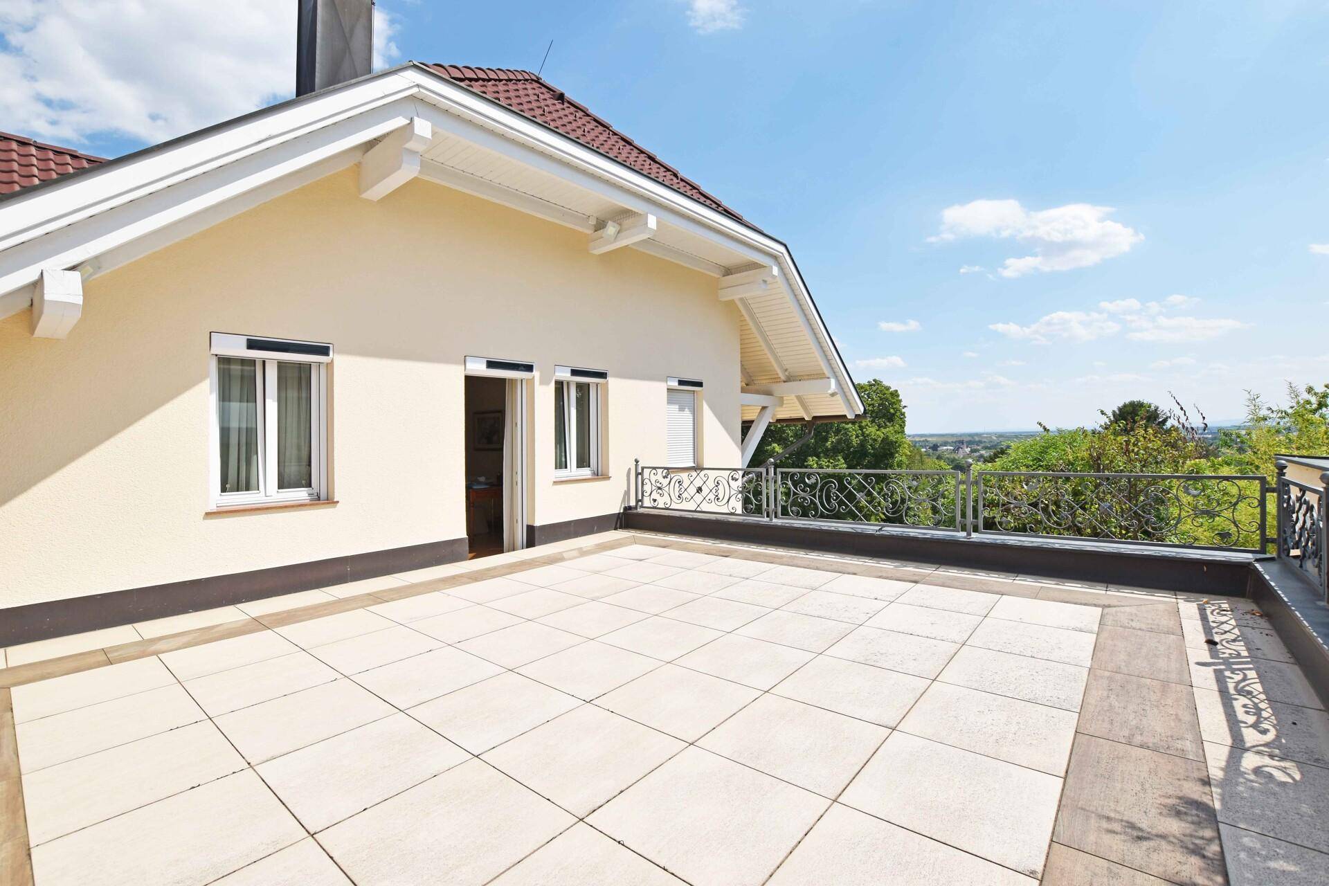 Große Sonnenterrasse mit weitem Ausblick über die Landschaft und dekorativem Geländer.