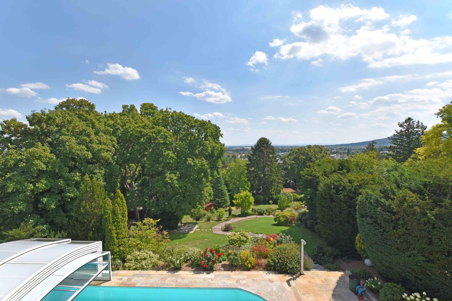 Weitläufiger Panoramablick über den gepflegten Garten, Pool und die umliegende Landschaft.