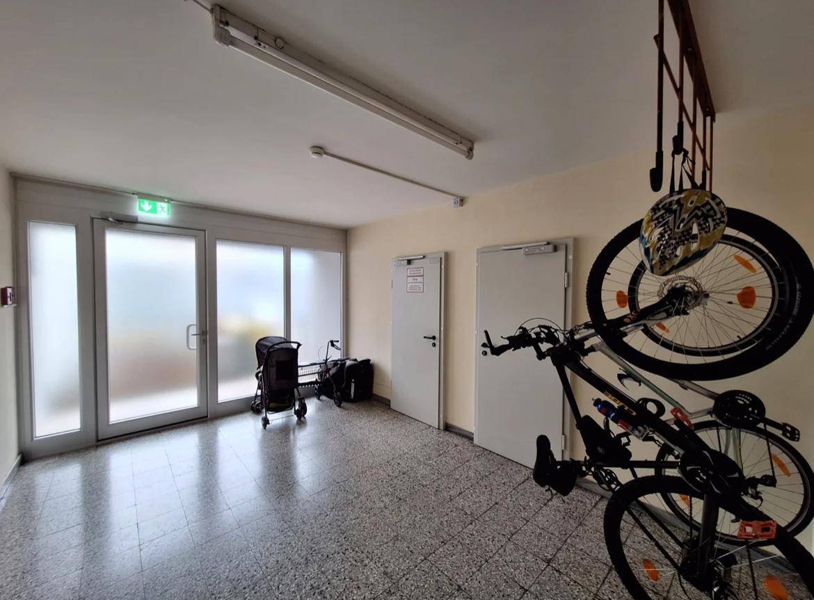Gemeinschaftlicher Eingangsbereich mit Fahrradabstellmöglichkeiten und hellen Glastüren.