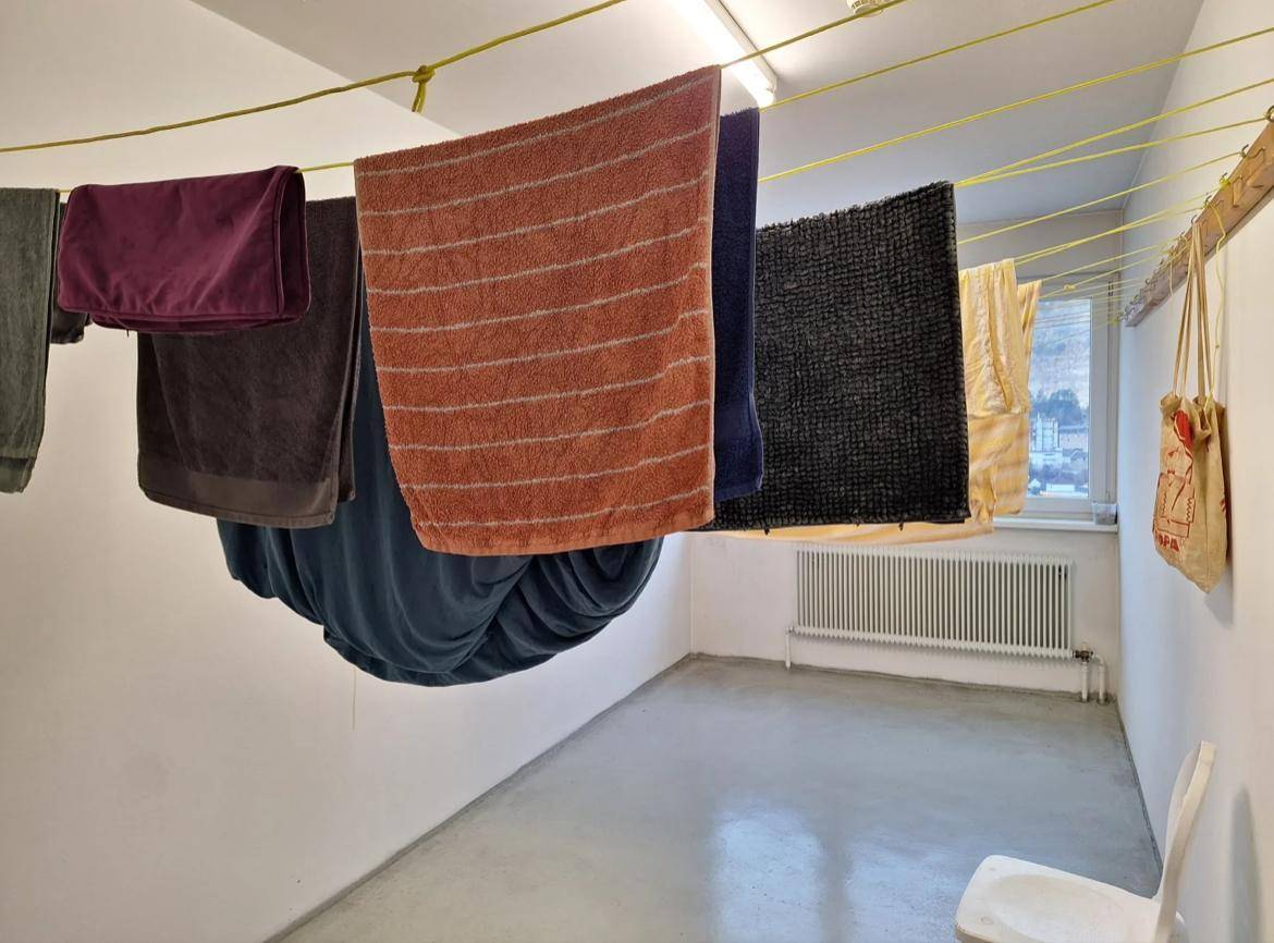 Gemeinschaftlicher Waschraum mit Wäscheleinen und Fenster für natürliche Belüftung.