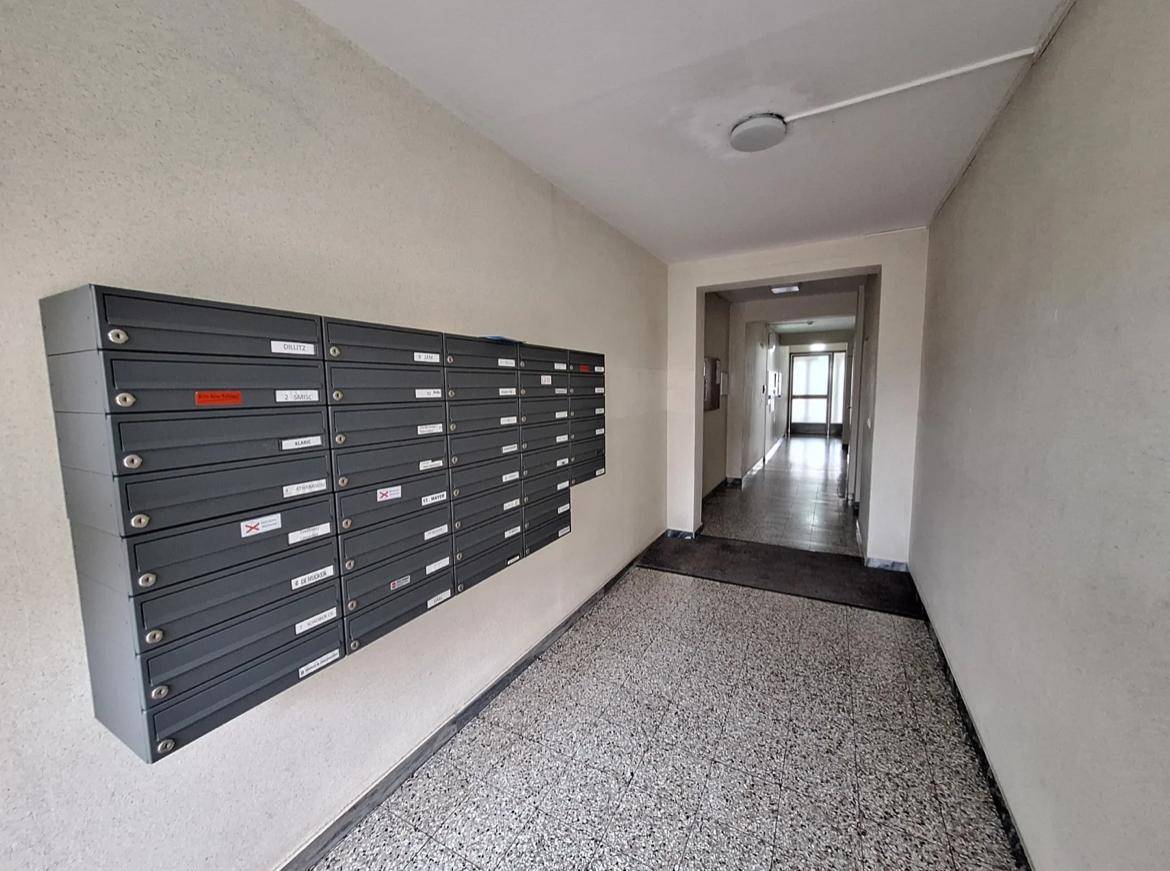 Gemeinschaftlicher Flur mit Briefkästen und Zugang zu weiteren Wohnbereichen.