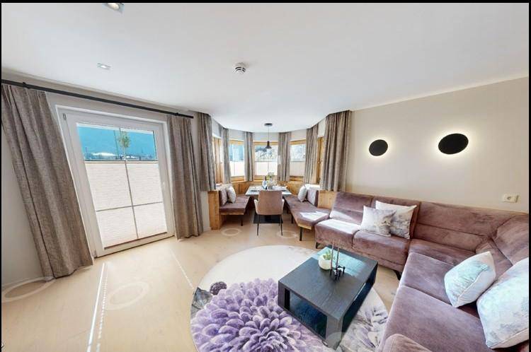 Gemütlicher offener Wohn- und Essbereich mit großen Fenstern, bequemer Couch und modernem Dekor.