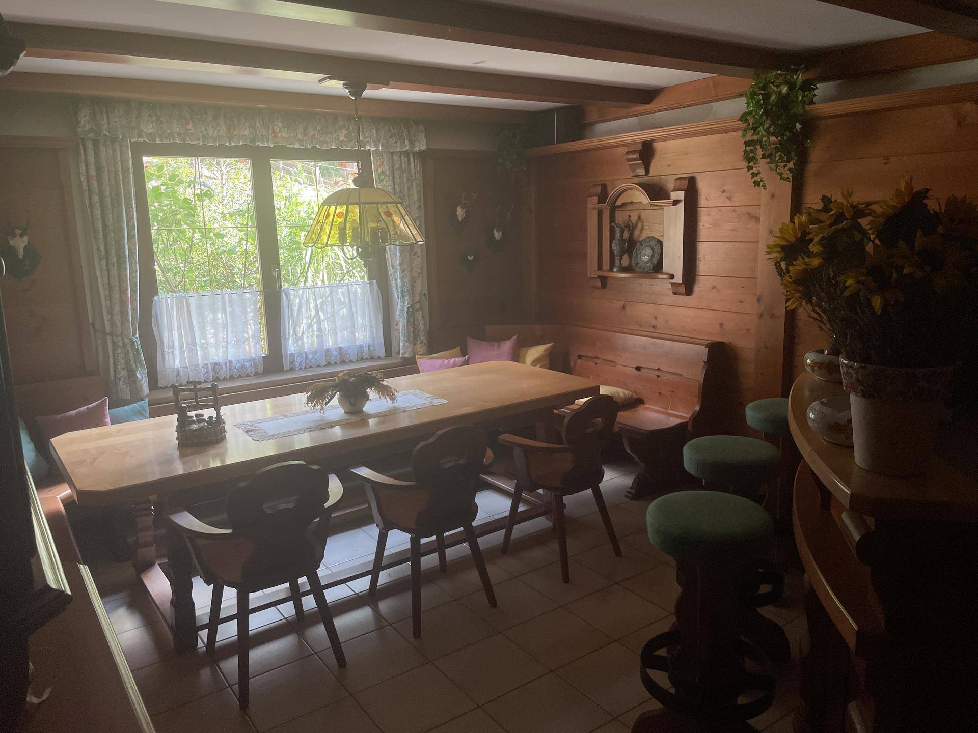 Traditioneller Essbereich mit Holztisch, Eckbank und rustikaler Dekoration.
