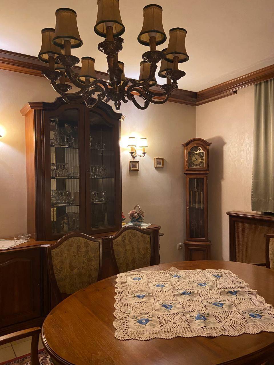 Klassischer Essbereich mit großem Holztisch, Vitrine und traditionellem Kronleuchter.