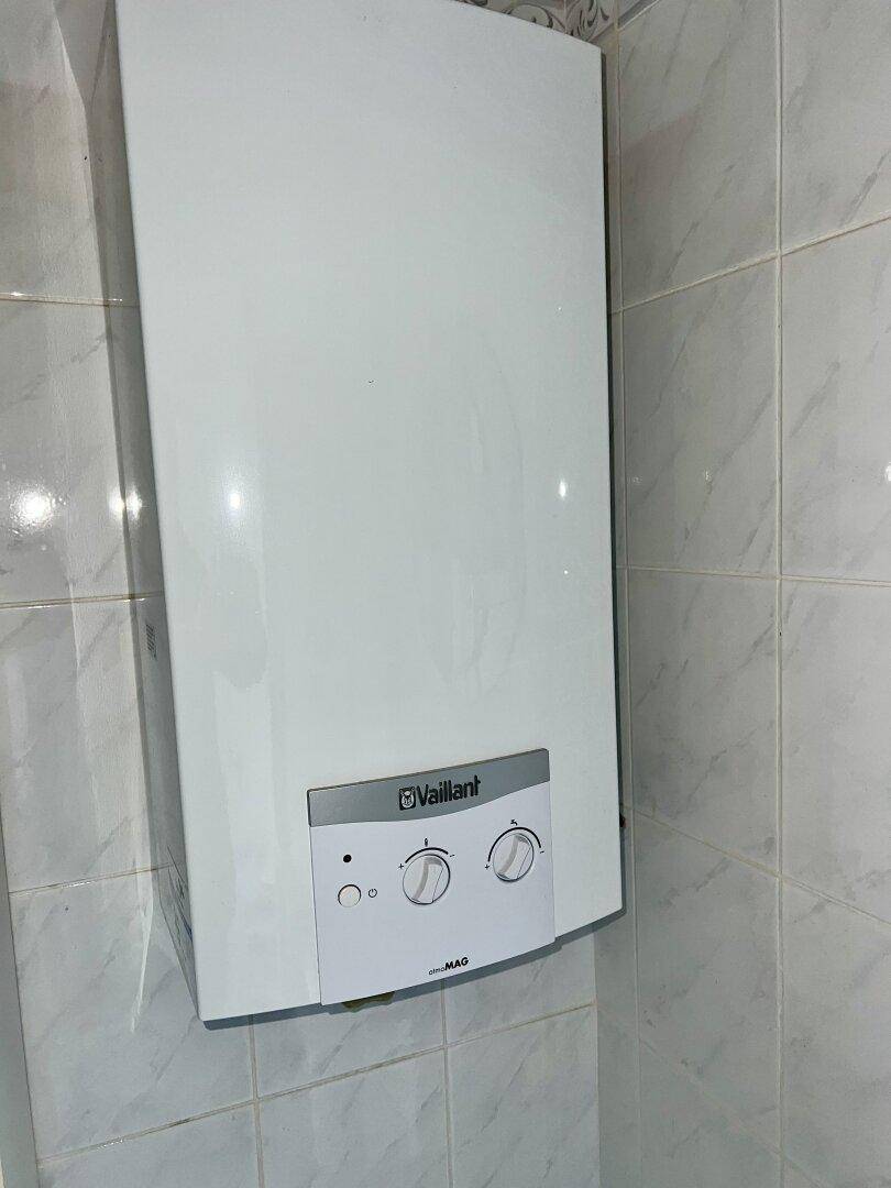 Wandmontierter Vaillant-Heizkessel in einem gefliesten Raum, wahrscheinlich ein Badezimmer oder Hauswirtschaftsraum.