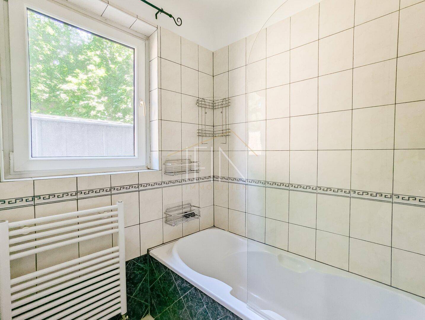 Badezimmer mit Fenster zum Garten