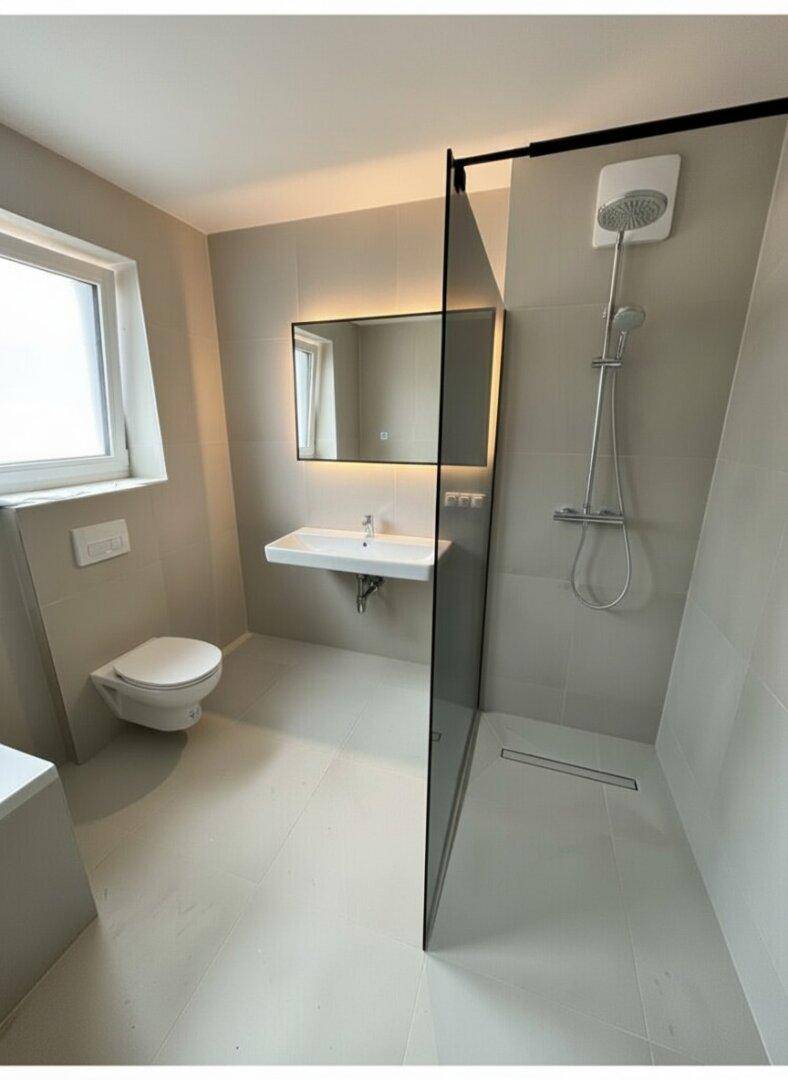 Helles Badezimmer mit großer begehbarer Dusche, modernem Waschtisch und Fenster.