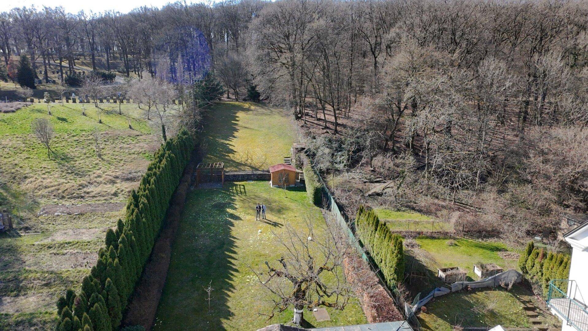 Luftaufnahme des Anwesens mit großem Garten, umgeben von Wald und weiteren Häusern.