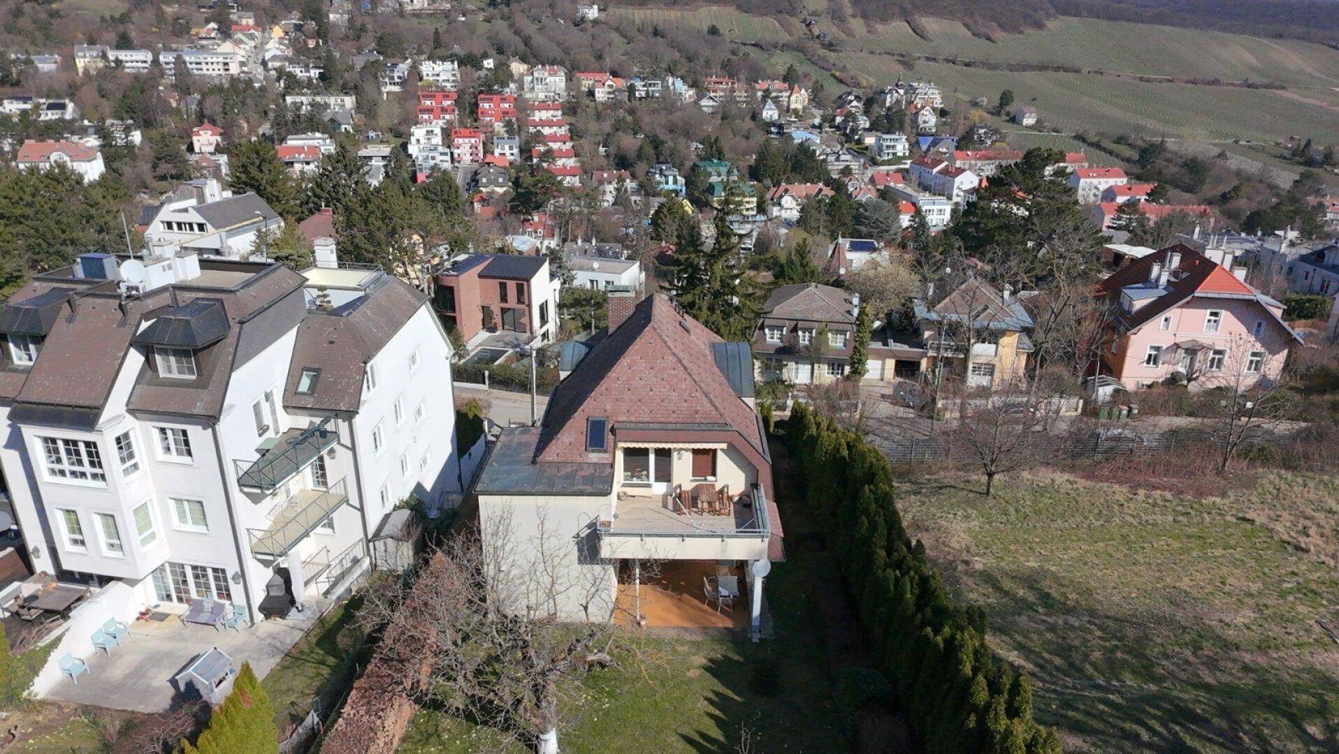 Luftaufnahme des Hauses mit Terrasse und Garten, eingebettet in die grüne Umgebung.