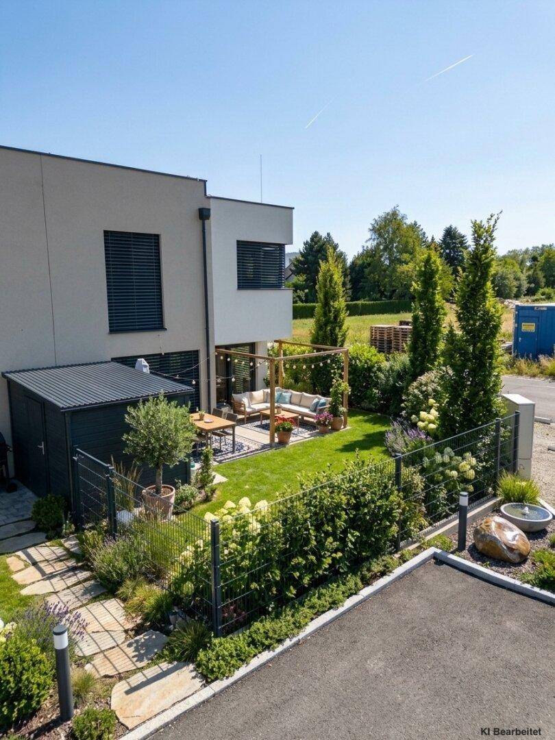 Attraktiver Gartenbereich mit Rasen, überdachter Lounge-Ecke, Essbereich und gepflegten Hecken und Bäumen.