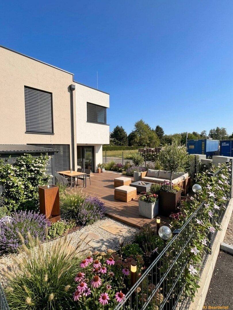 Großzügige Holzterrasse mit moderner Lounge-Gruppe, Esstisch und farbenfrohen Blumenbeeten für entspannte Stunden.