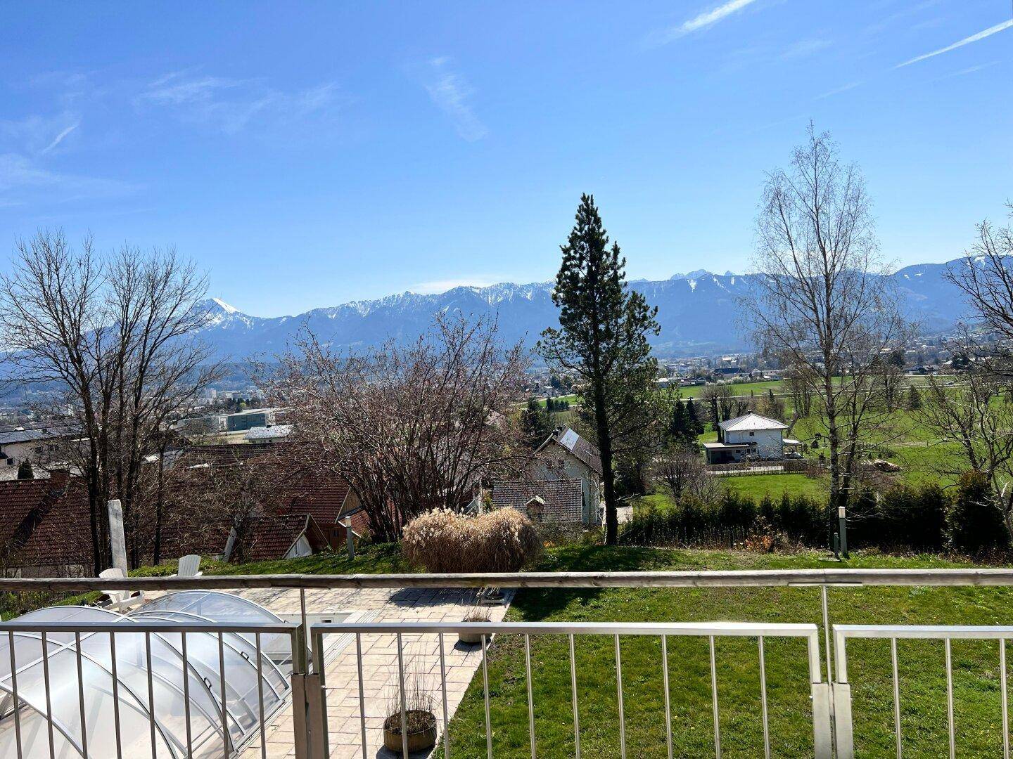 Weitläufiger Panoramablick auf die Berge und die umliegende Landschaft von einem Balkon oder einer Terrasse.
