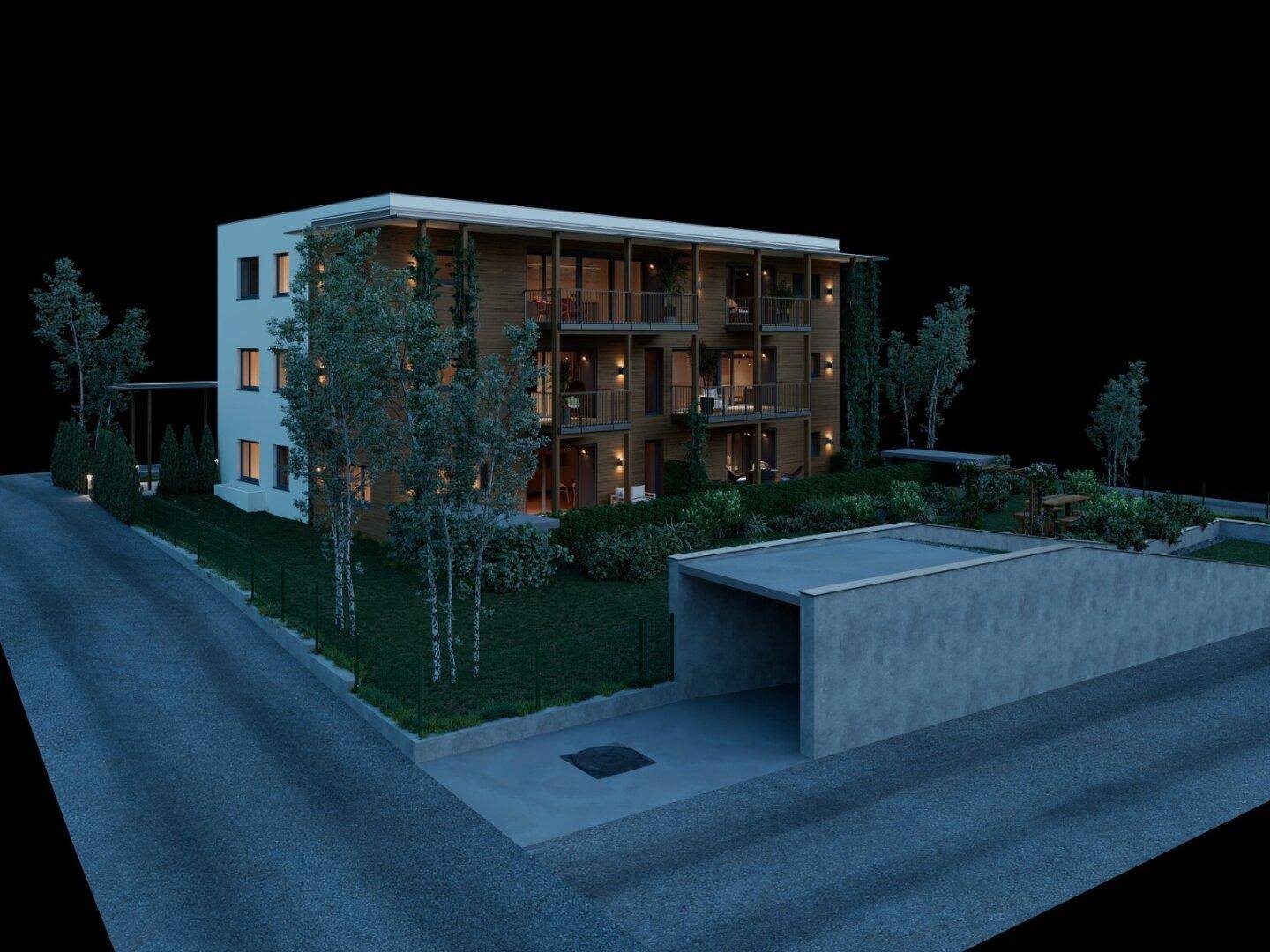 Gesamtansicht der Wohnanlage bei Nacht mit Holzfassade, Gärten und Tiefgaragenzufahrt.