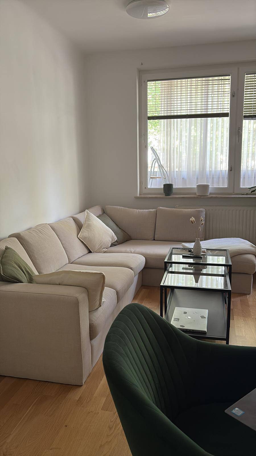 Gemütliches Ecksofa mit Couchtisch und Fenster mit Jalousien im Wohnbereich.