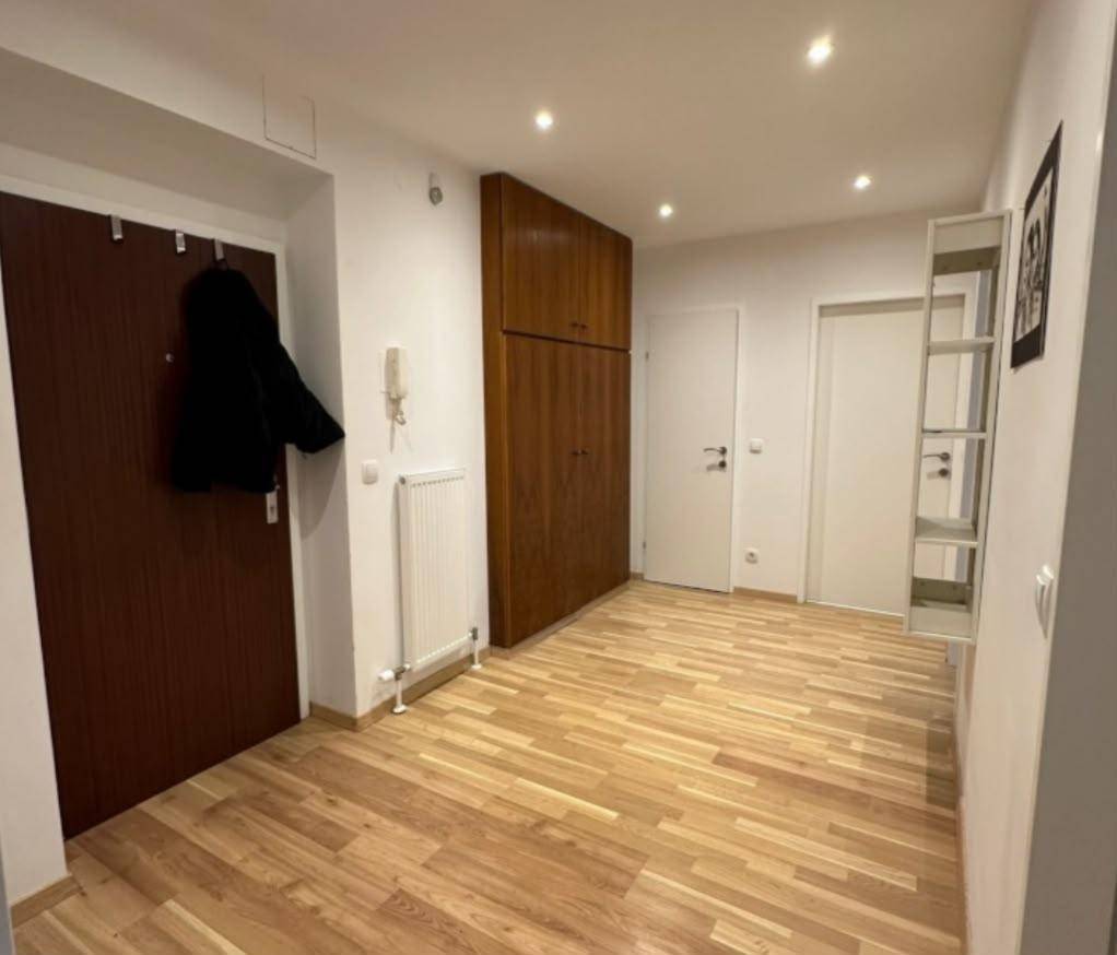 Geräumiger Flur mit Holzfußboden, Einbauschränken und Garderobe, bietet viel Stauraum.