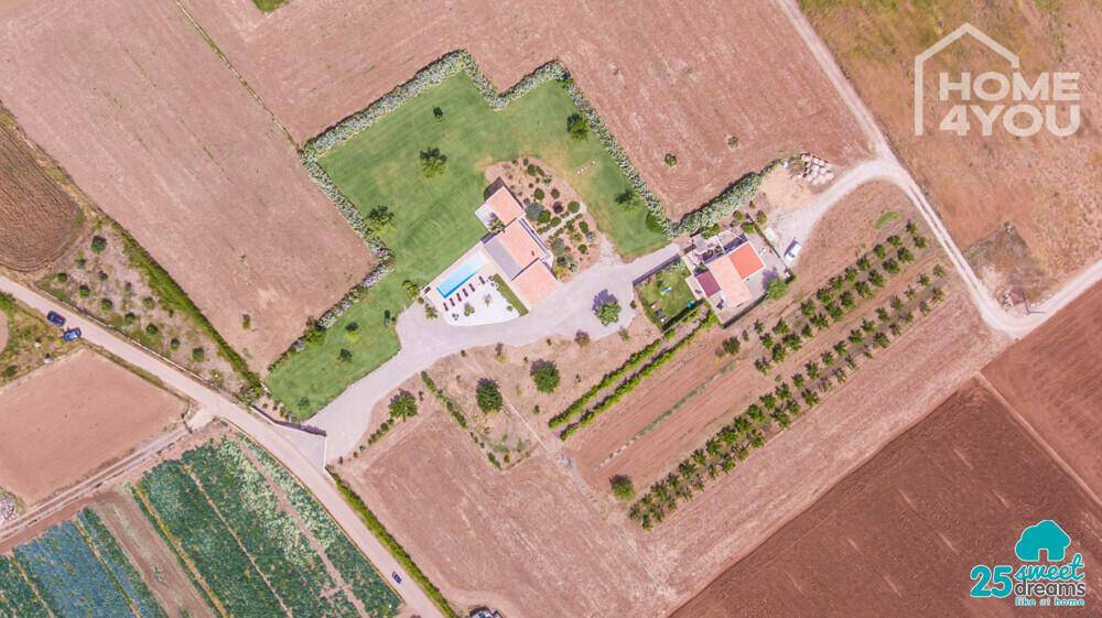 Weitwinkel-Luftaufnahme des gesamten Anwesens mit angrenzenden landwirtschaftlichen Flächen.