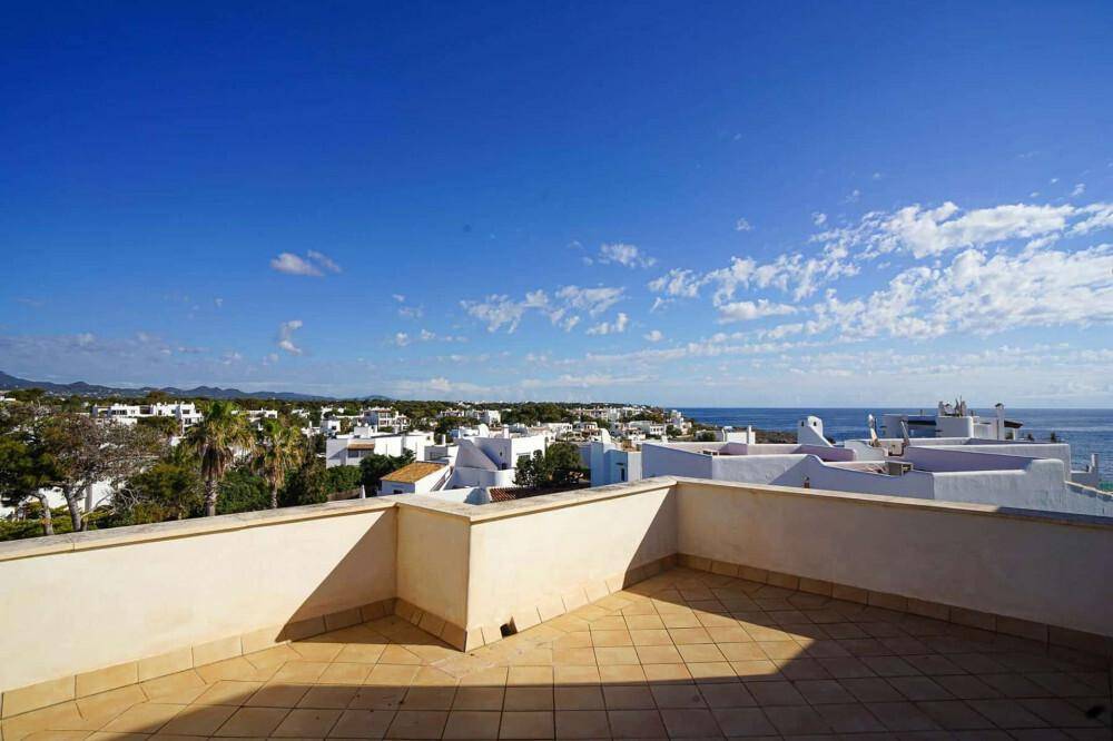 Weitläufige Dachterrasse mit Fliesenboden und Panoramablick auf die Küste und das Meer.