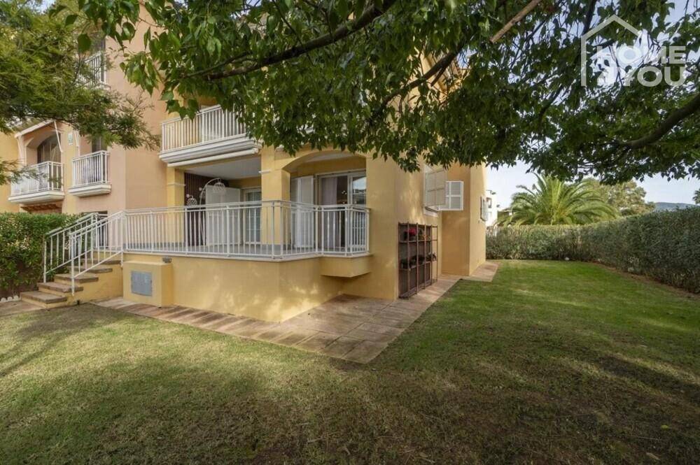 Sonnige Rasenfläche mit Terrasse und üppiger Hecke, ideal zum Entspannen.