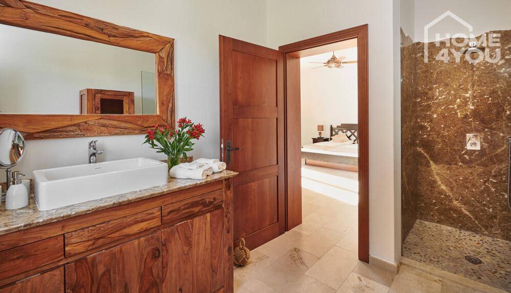 Modernes Badezimmer mit Holzwaschtisch, Aufsatzwaschbecken und begehbarer Dusche.