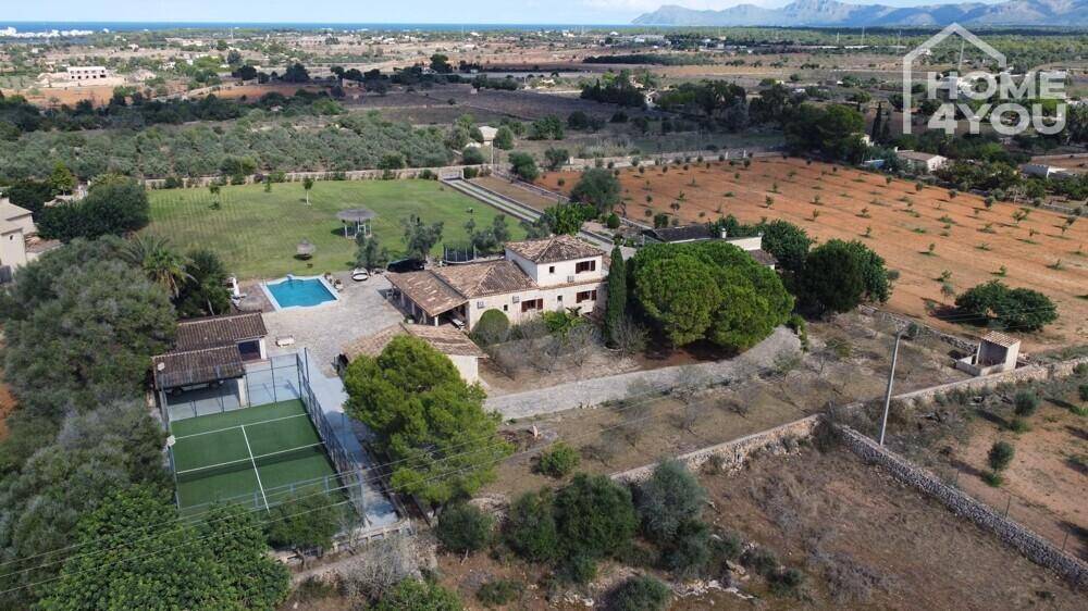 Luftaufnahme des weitläufigen Anwesens mit Pool, Tennisplatz und umliegender Landschaft.