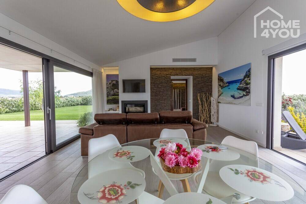 Gemütlicher Wohn- und Essbereich mit Kamin, bequemen Sofas und direktem Zugang zum Garten.