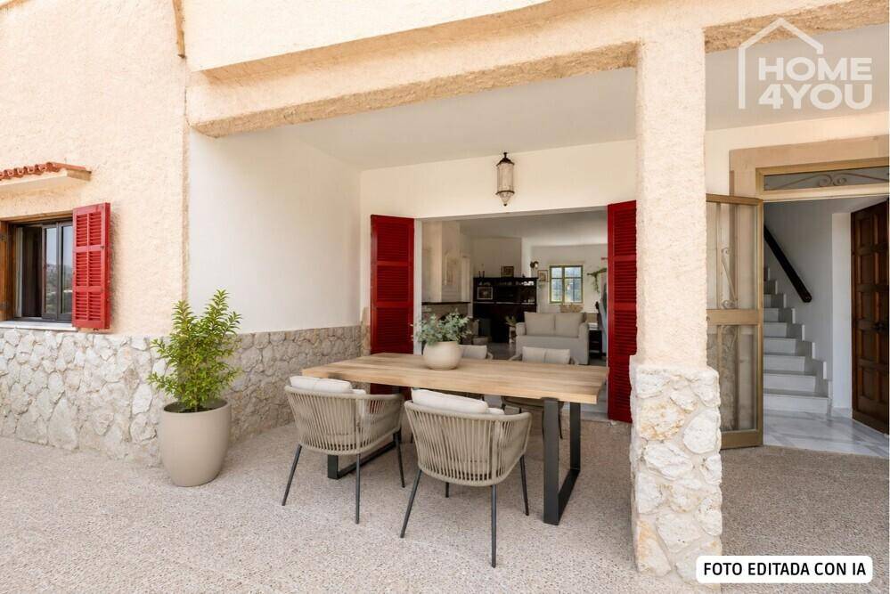 Überdachte Terrasse mit modernem Esstisch und Stühlen, direkt am Hauseingang gelegen.