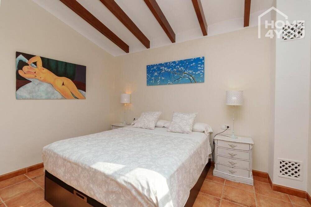 Gemütliches Schlafzimmer mit Doppelbett, Holzbalkendecke und Terrakottaboden.