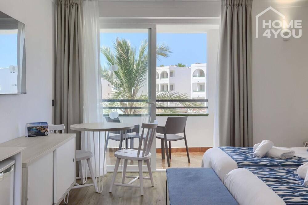 Helles Schlafzimmer mit zwei Einzelbetten und direktem Zugang zu einem kleinen Balkon.