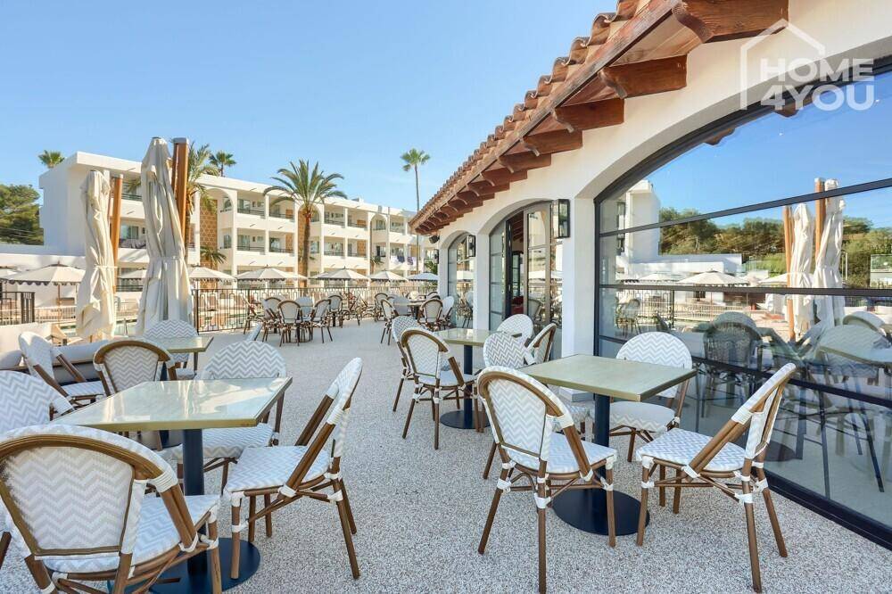 Große Restaurantterrasse im Freien mit zahlreichen Tischen und Stühlen, sonnig gelegen.