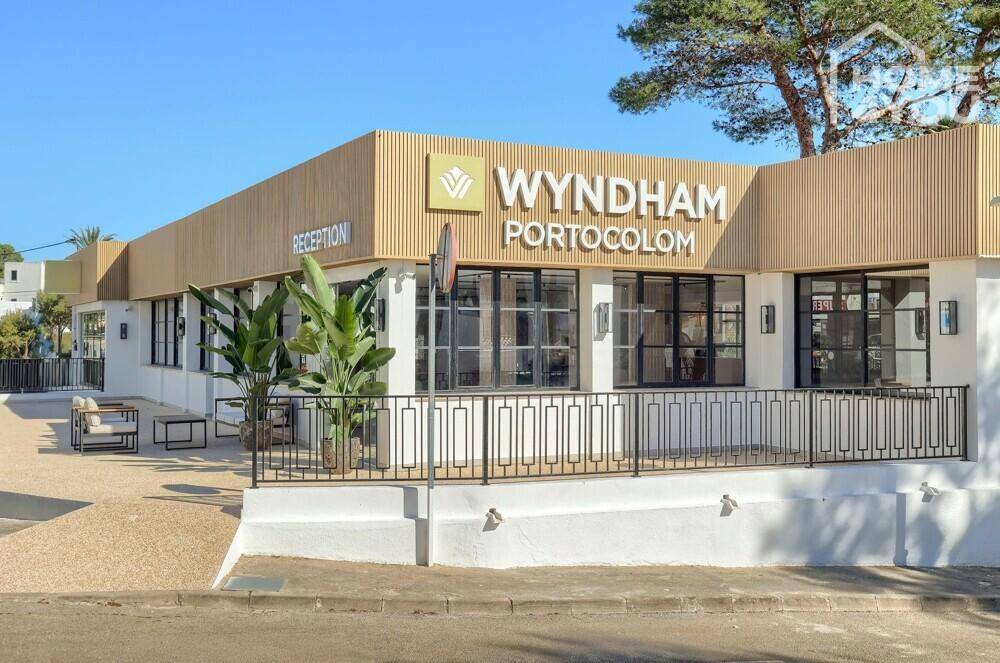 Außenansicht des Wyndham Portocolom Hotels mit moderner Fassade und Empfangsbereich.
