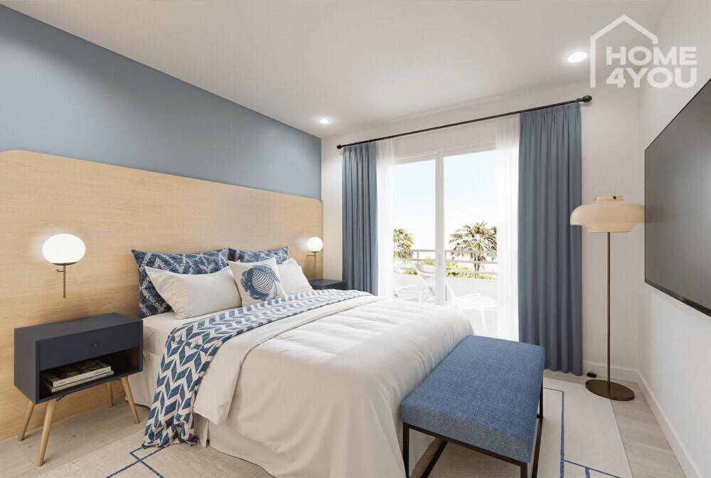 Modernes Schlafzimmer mit Doppelbett, blauer Akzentwand und Balkonzugang.