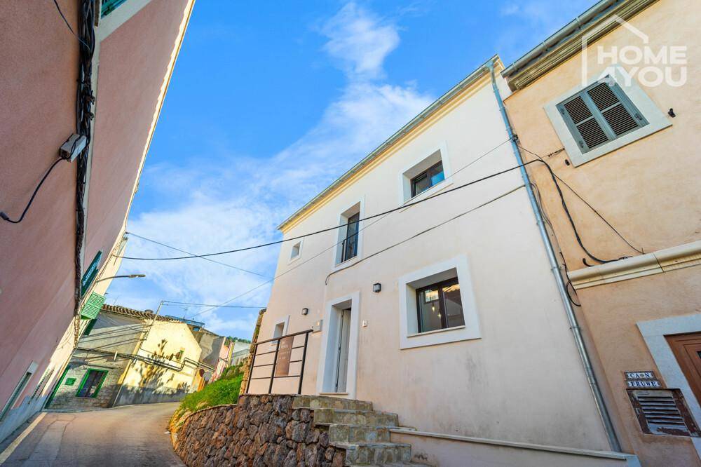 Moderne Außenansicht des Gebäudes in einer charmanten Gasse mit Treppenzugang zum Eingang.