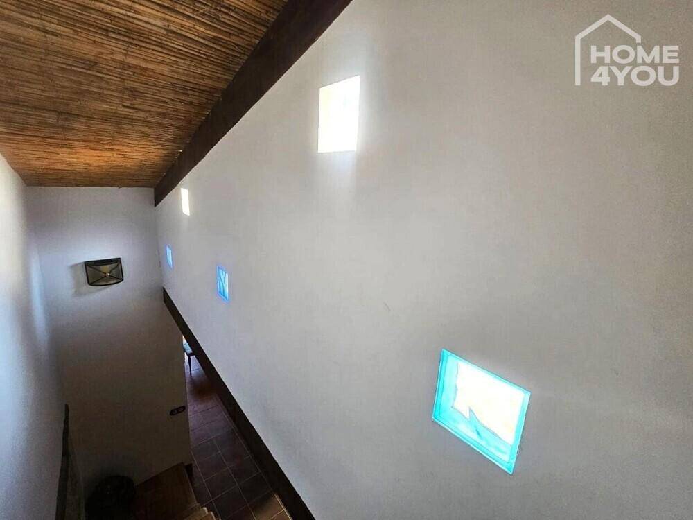 Heller Flur mit farbigen Fenstern und einer Decke aus Bambus oder Holzgeflecht.